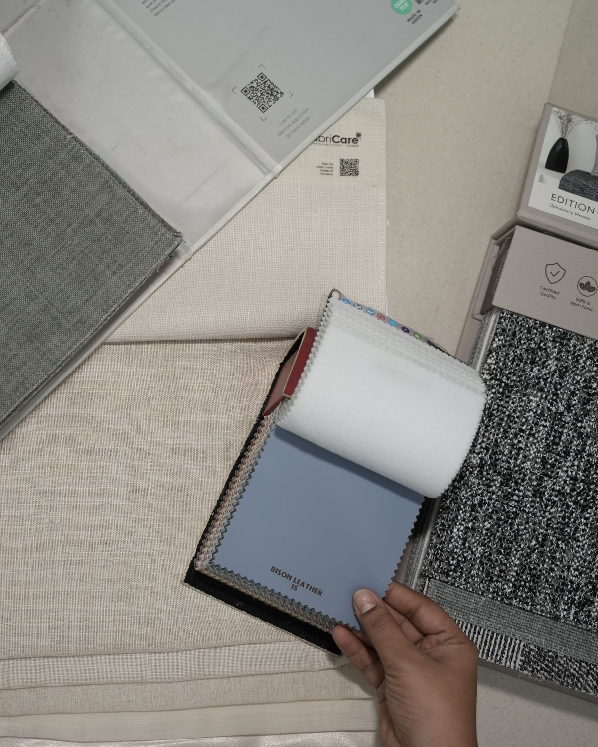 Customer browsing fabric swatch books at Drape Shoppe Surat