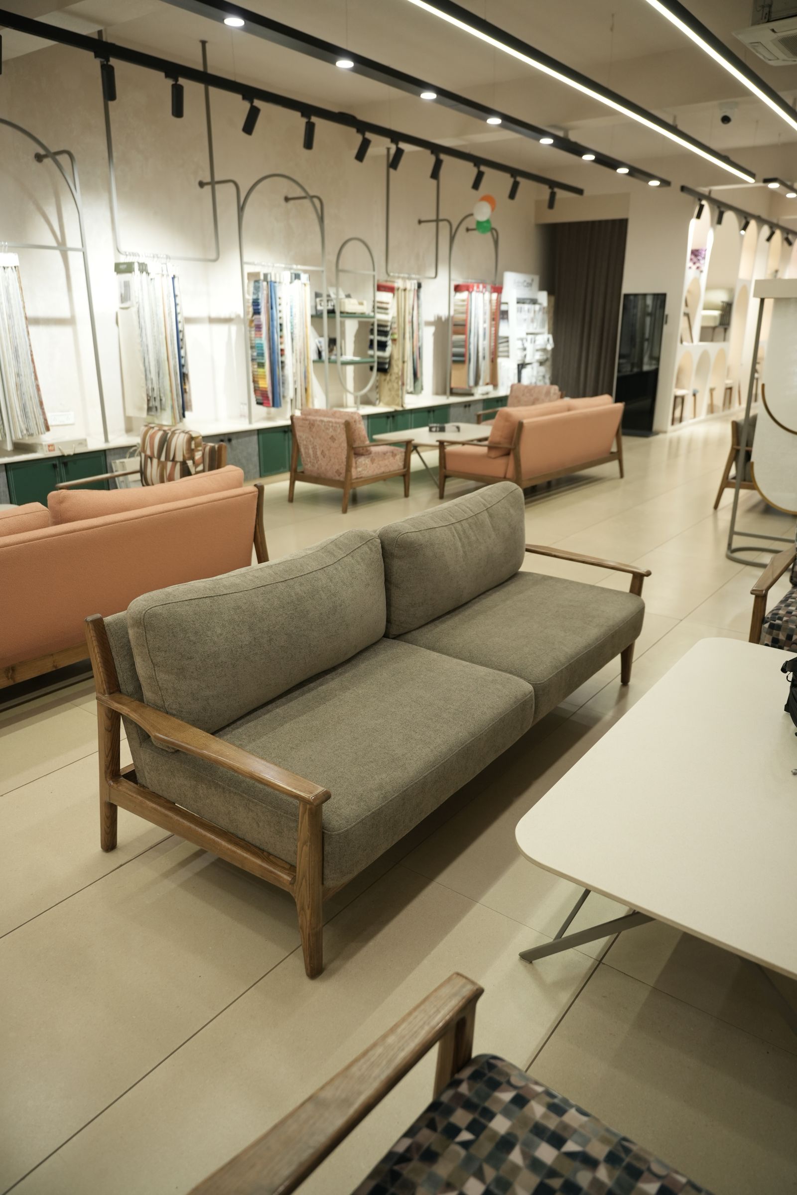 Display floor at the Drape Shoppe Surat showroom with sofas and curtain displays