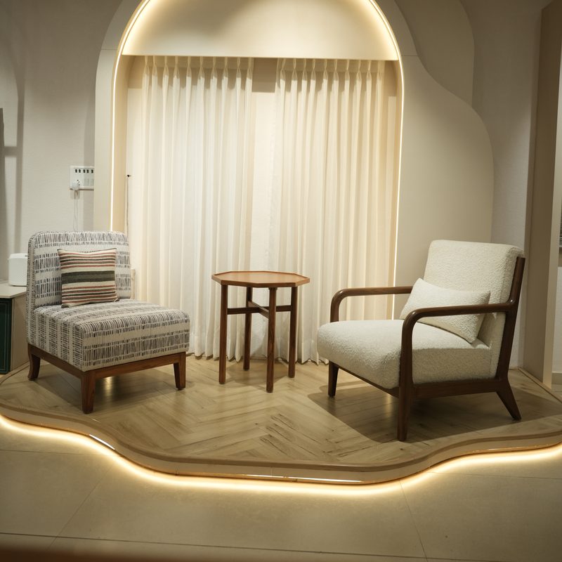 Lounge chairs and side table in a lit arched alcove at Drape Shoppe