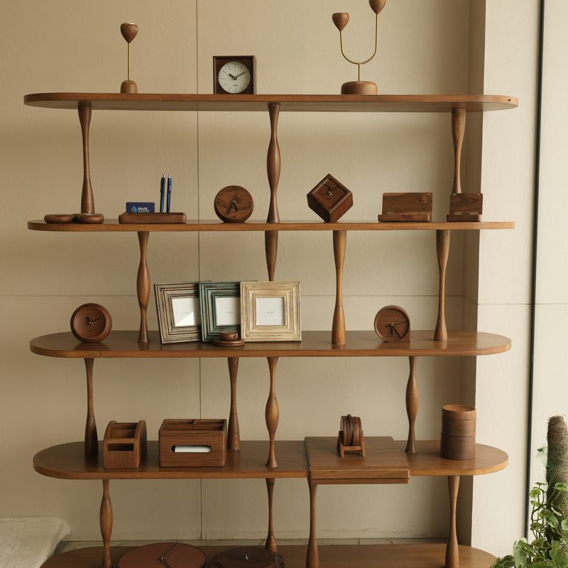 Wooden shelf styled with clocks, frames and décor at Drape Shoppe